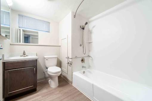 A white bathroom with a toilet, sink, and bathtub.