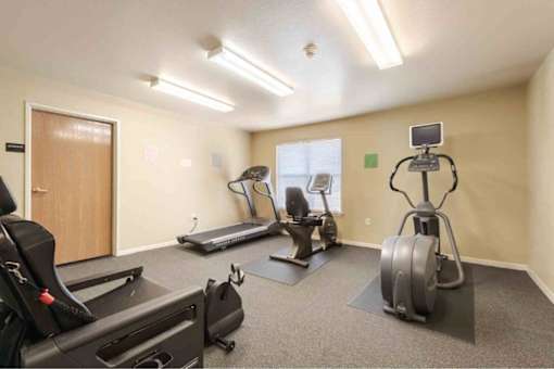 A well-equipped gym with treadmills, elliptical machines, and a stationary bike.