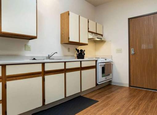 A kitchen with wooden cabinets and a white countertop.