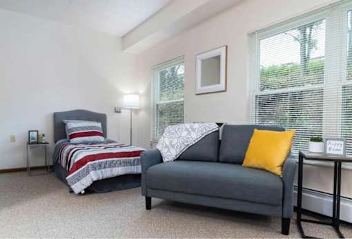 A bedroom with a bed and a couch.