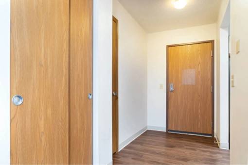 A room with a wooden door and a wooden door with a glass panel.