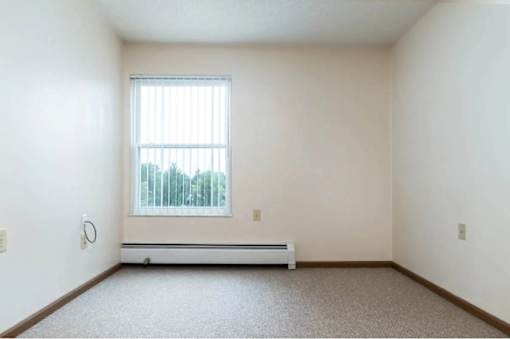 A room with a window and a bench.