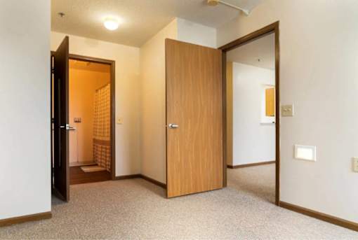 A hallway with two doors and a carpeted floor.