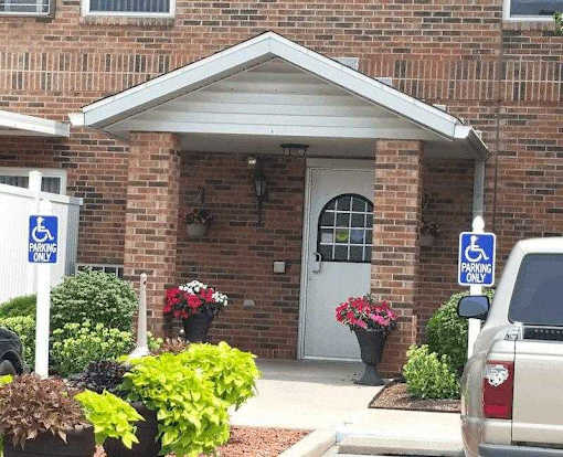 A building with a white door and two signs that say "Handicap Only" on the side of it.