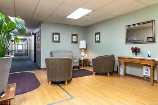 A waiting room with chairs, a desk, and a mirror.