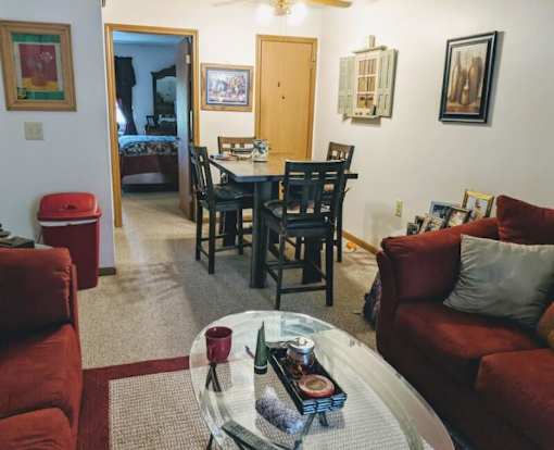 A living room with a glass coffee table in the middle.