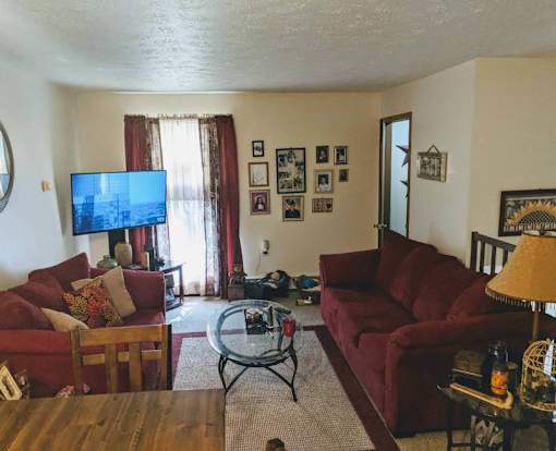 A living room with red couches and a flat screen TV.
