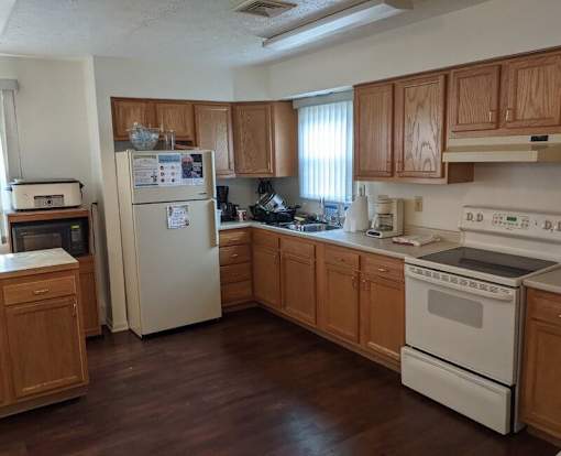 A kitchen with wooden cabinets and white appliances.