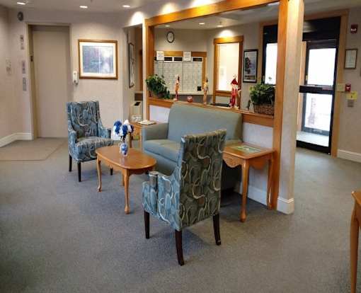 A waiting room with two chairs and a sofa.