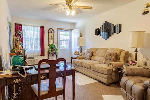 A living room with a tan couch and a wooden table.