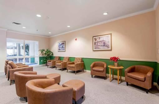 A waiting room with brown chairs and a green wall.