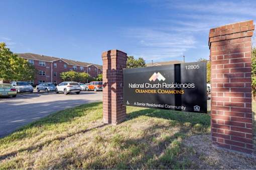 The sign in front of the brick wall reads "National Cut Residential Commons Oleaner Commons".