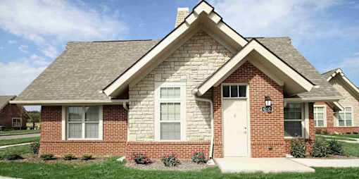 A brick house with a white door and windows.