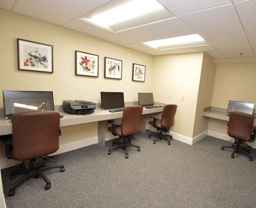 A room with a desk and chairs and pictures on the wall.