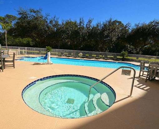 A pool with a blue tiled edge and a metal railing.