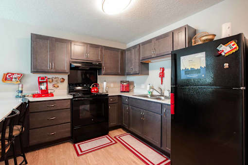A black refrigerator with a magnet on it in a kitchen.