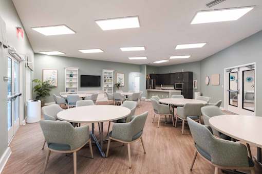 A room with tables and chairs and a whiteboard.