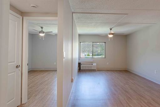 A room with a white ceiling and a window with a white sofa.