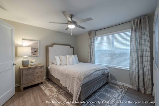 A bedroom with a bed, nightstand, and window.