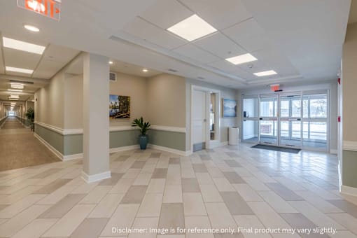 A spacious hallway with tiled floors and white columns.
