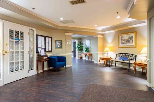 A spacious living room with a blue sofa and wooden floors.