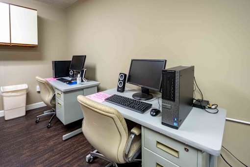 Two computers on desks in a room.