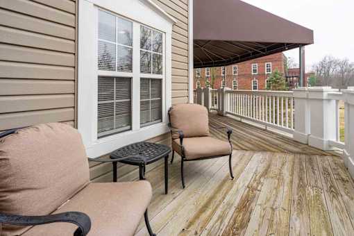 A wooden deck with two chairs and a table.