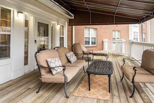 A patio with a couch, chairs, and a table.