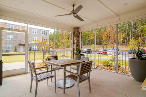 A patio with a table and chairs and a ceiling fan at Sweetwater Point in Douglasville, GA