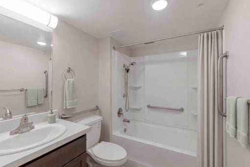 A white bathroom with a toilet, sink, and bathtub.