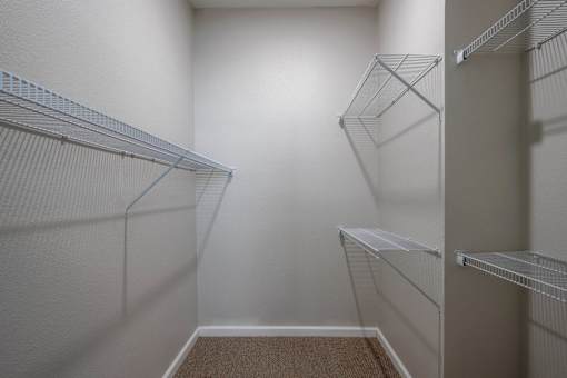 A walk-in closet with white shelving and a carpeted floor at Sunday Village, Austin
