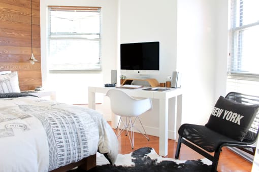 a bedroom with a desk and chair in front of a window