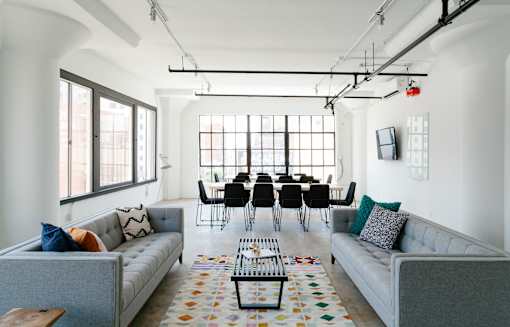 an open living room with two couches and a coffee table in front of a large window