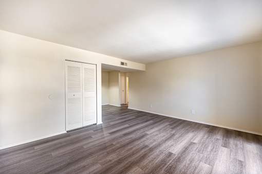 A room with a white door and a wooden floor.