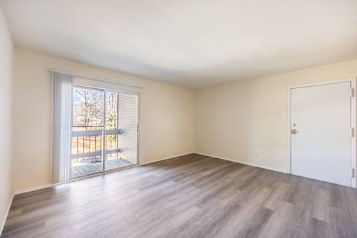 A room with a sliding glass door leading to a balcony.