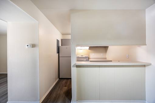 A kitchen with a refrigerator, sink, and cabinets.