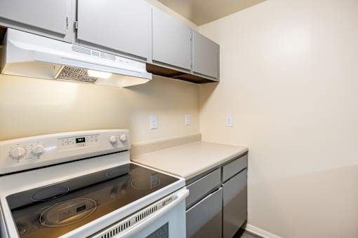 A white stove and oven in a kitchen with white cabinets.