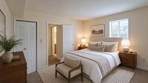 A bedroom with a bed, chair, and lamp.