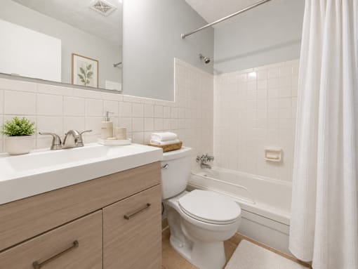 A white bathroom with a toilet, sink, and bathtub.