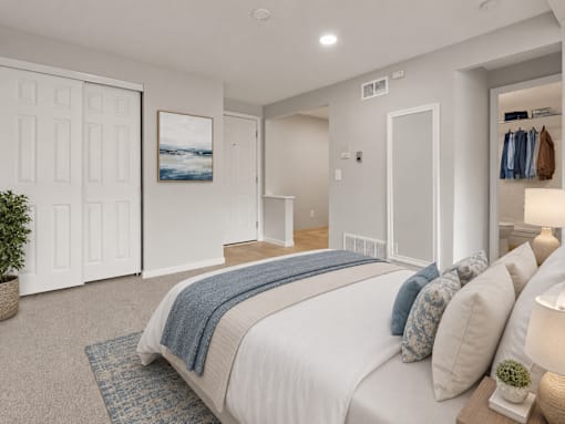 A bedroom with a large bed and a painting on the wall.