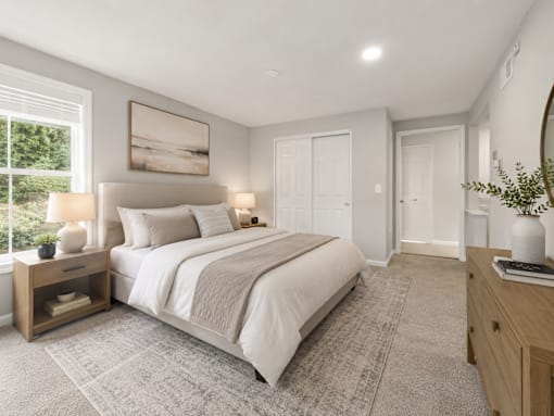 A bedroom with a large bed, a nightstand with a lamp, and a painting on the wall.