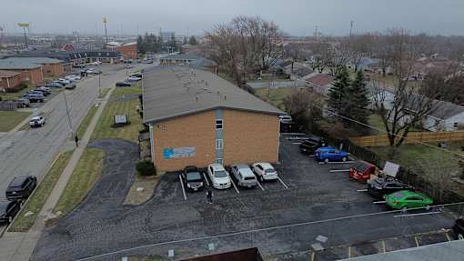 A parking lot with cars and a building in the background.