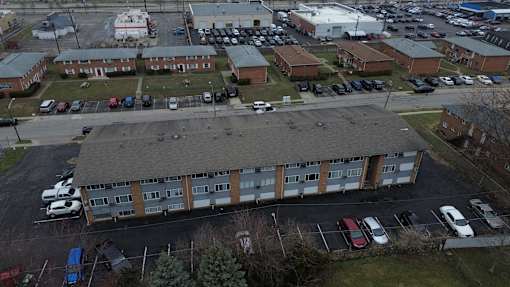 A parking lot with cars and a building in the background.