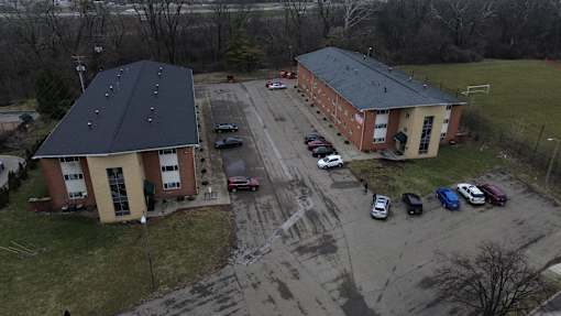 A parking lot with cars and two buildings.