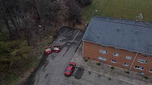Two red cars are parked in a parking lot.