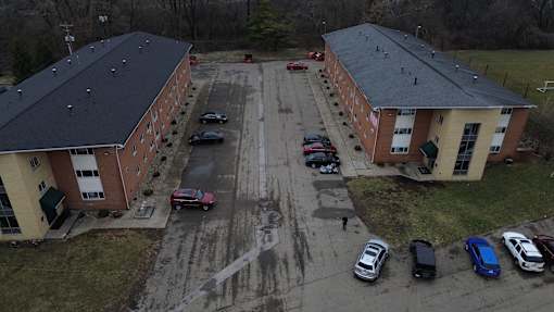 A parking lot with cars parked in front of a building.