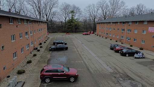 A parking lot with cars and apartment buildings.