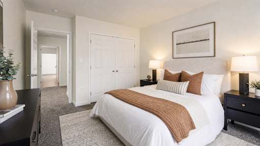 A bedroom with a large bed and a painting on the wall.