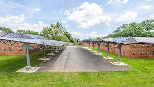 A long building with a green lawn in front.