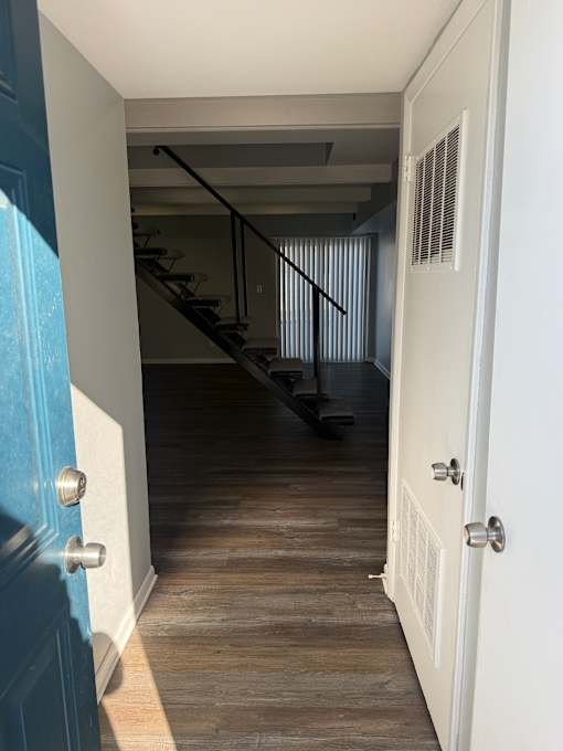 A room with a staircase and a wooden wall.